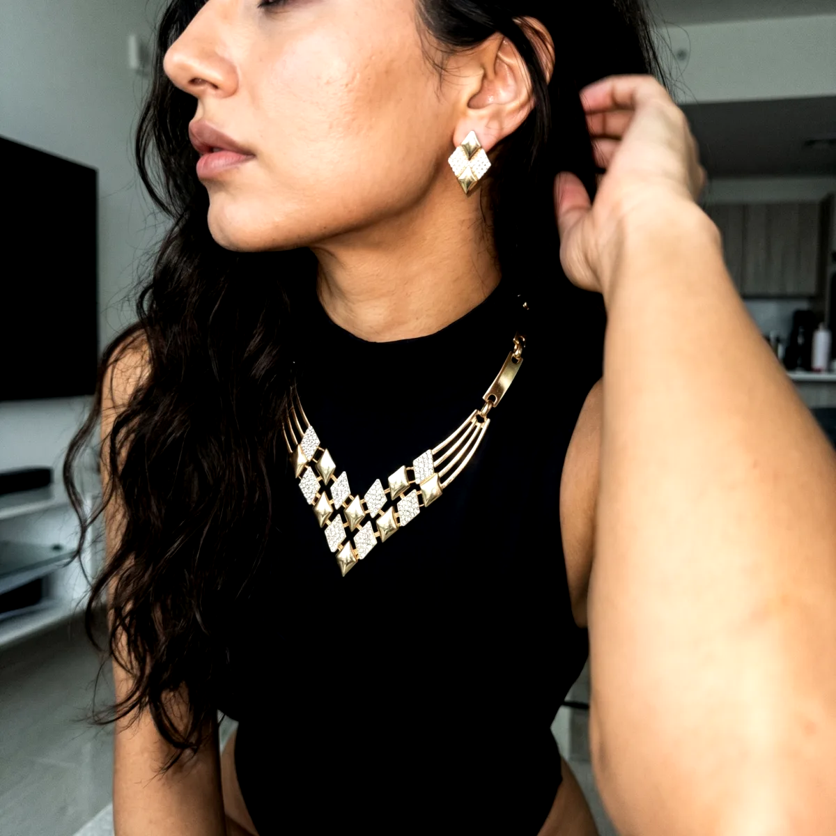 AI generated jewelry photo of a gold statement necklace and matching earrings on a model in a black top