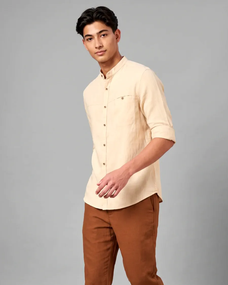 AI generated studio photo of a young man walking in a cream linen band collar shirt and rust trousers on a grey backdrop