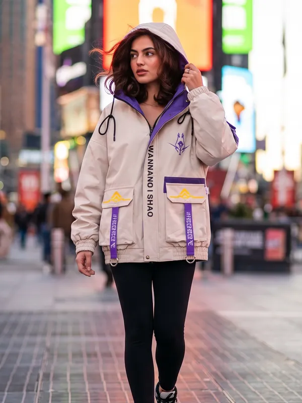 AI generated on-model photo of a cream streetwear jacket worn by a model walking through a city at twilight
