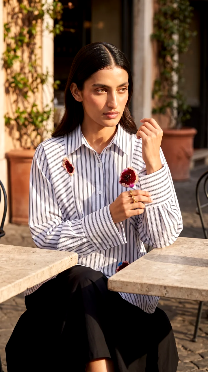 Closer, at a cafe table: the wide cuff folded back and a flower patch on the chest